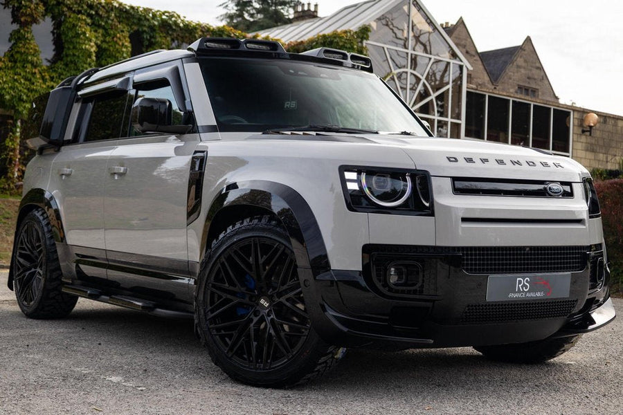 Land Rover Defender L663 in white with black arches and 22 inch forged wheels, photographed on the RS Auto forecourt